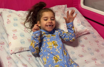 A young girl lying in her SleepSafe bed