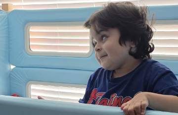 A young boy at the side of his SleepSafe bed