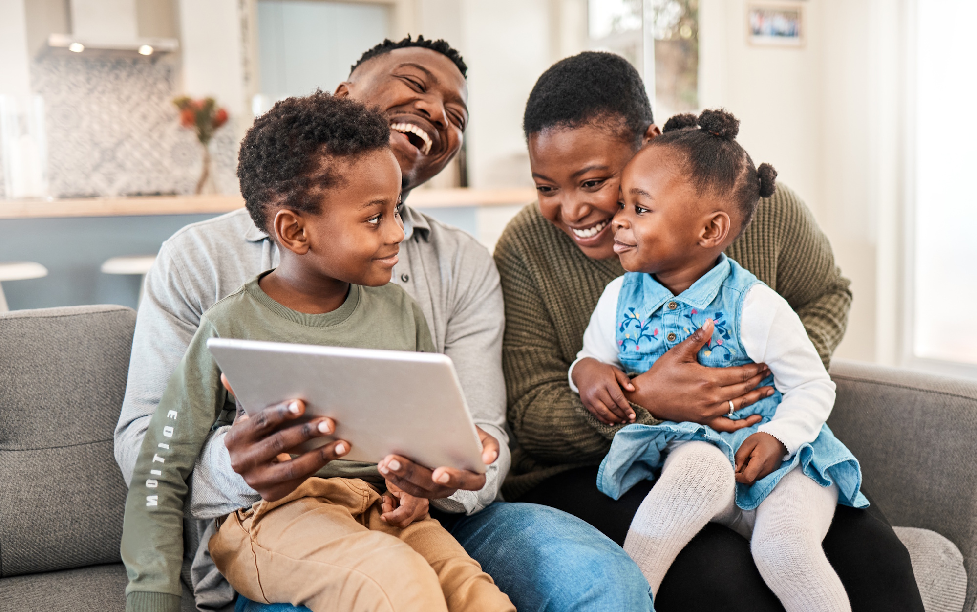 A family of four seated on a couch.