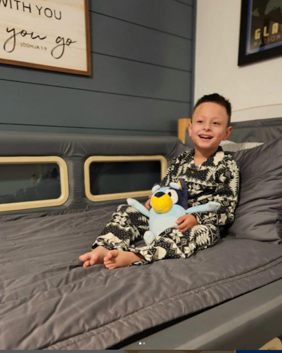 A young boy sitting in a SleepSafe bed.
